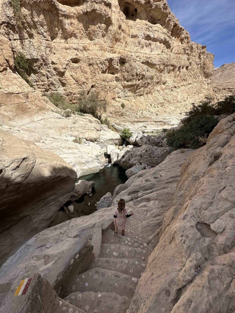 Child walking down concrete steps that have been built into the side f the valley to make it easier to access