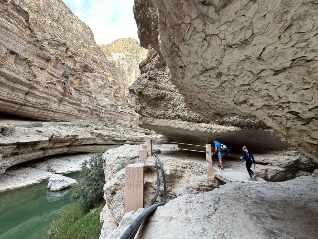 Family walk along rocky path above the first pool of turquoise water