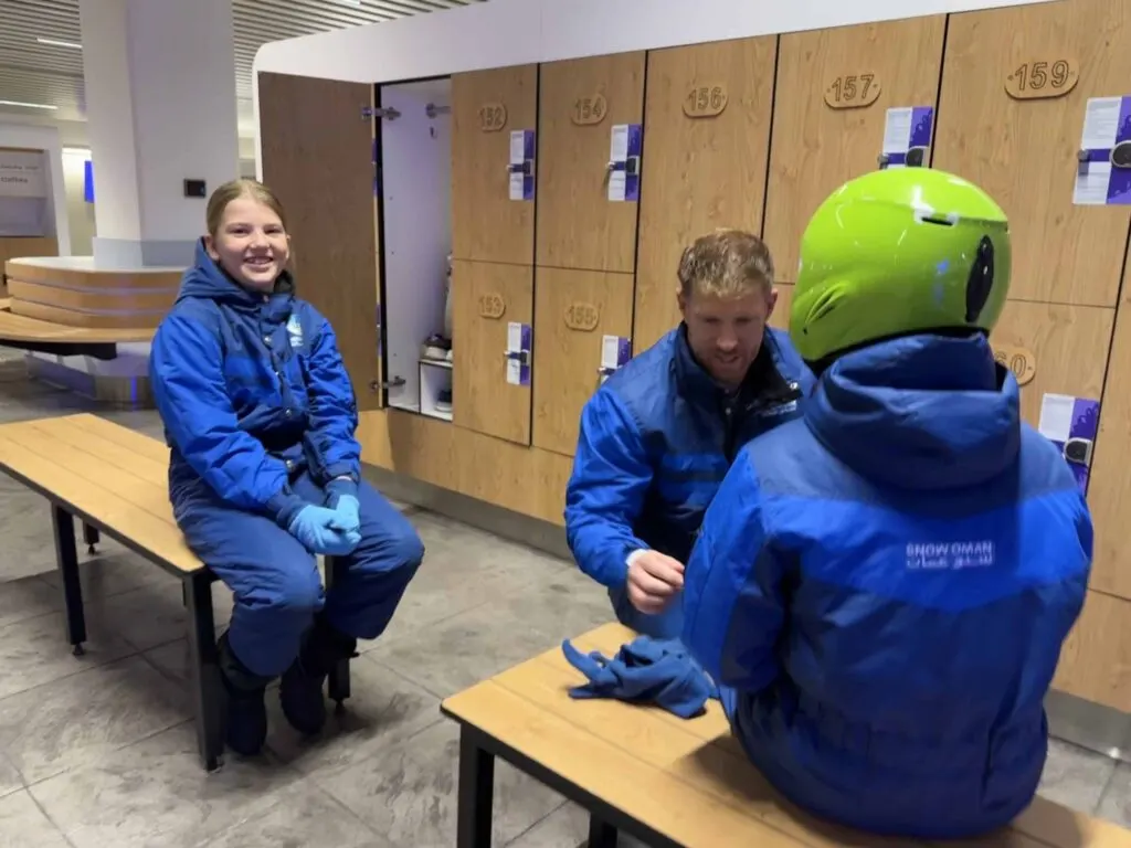 Family wearing snow suits in the changing room at Snow Oman