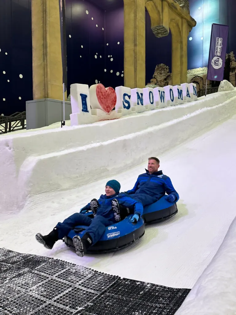My daughter and husband in a double Ringo coming down an ice slope at Snow Oman. There is an I love Snow Oman sign in the background