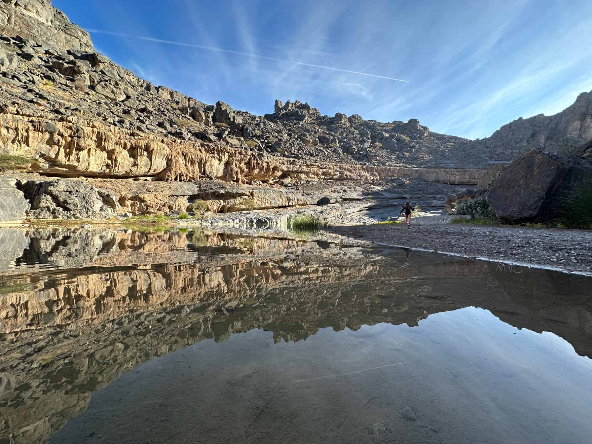Reflections of the walls of a valley in still water in Wadi Damm, one of the incredible things to do in Oman