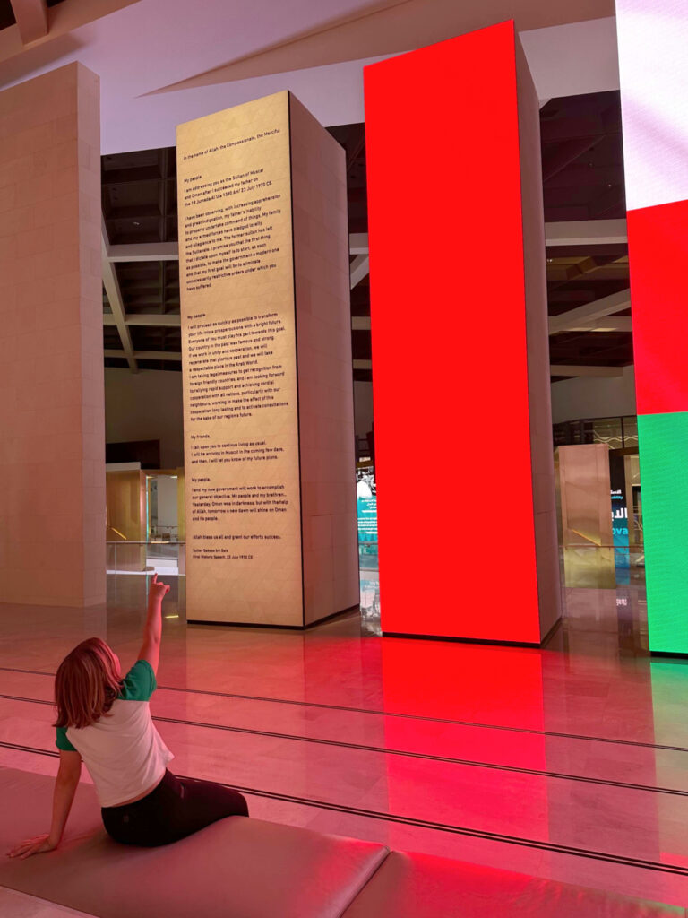 Child pointing up at tall electronic display boards