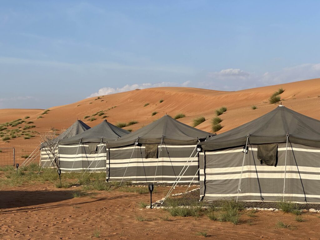 Traditional bedouin-style tents lined up against a desert backdrop