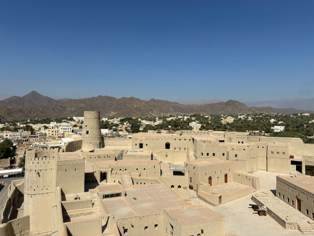 A view over the top of Bahla Fort in the Hajar Mountains which you can see in the distance