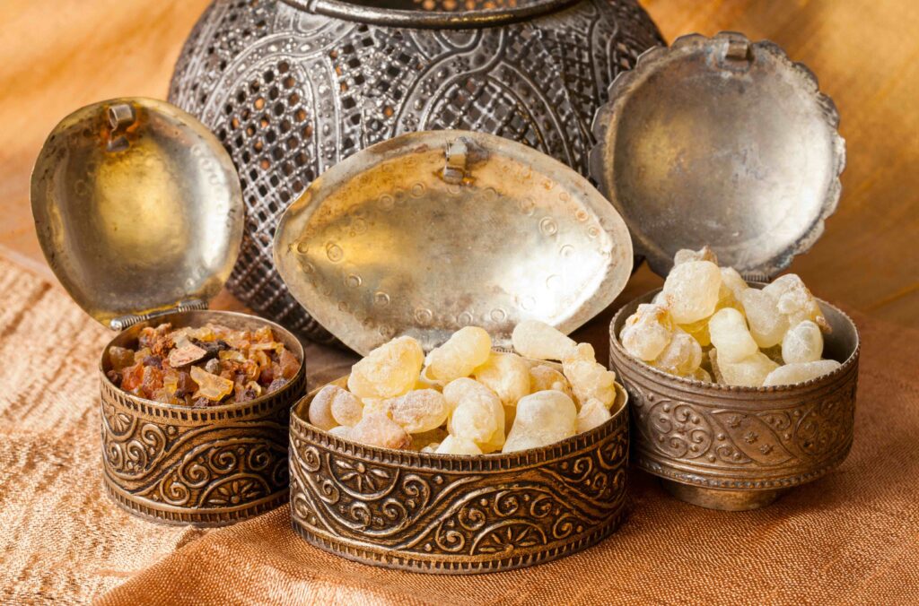Three silver containers filled with nuggets of frankincense 