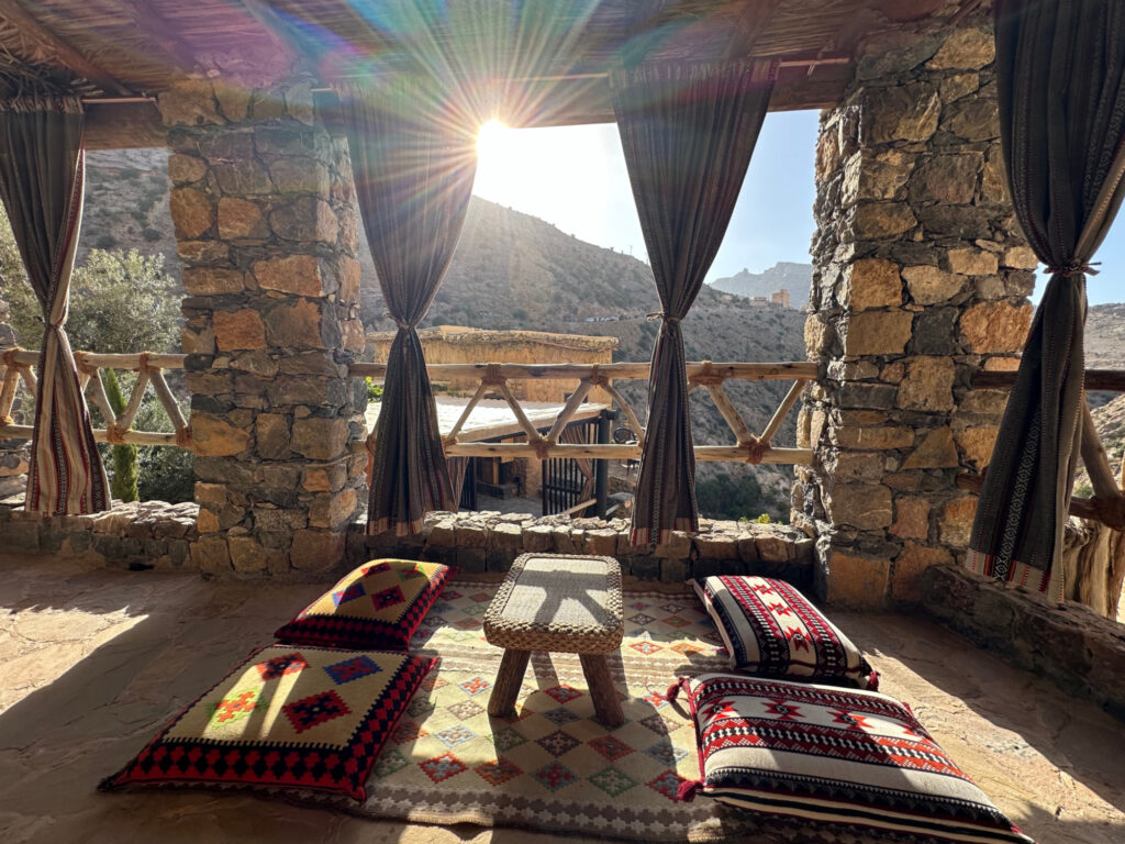 The sun beams through the balcony seating area in the Al Arsha Suite. there is a traditional Omani seating area on the floor