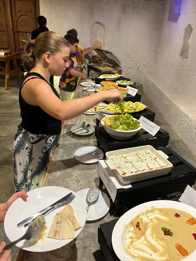 Our daughter serving herself salad at the evening buffet