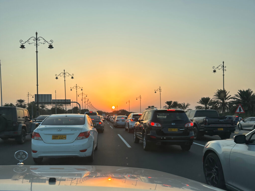 Cars stationary on he Sultan Qaboos Street motorway in Muscat. The sun is setting
