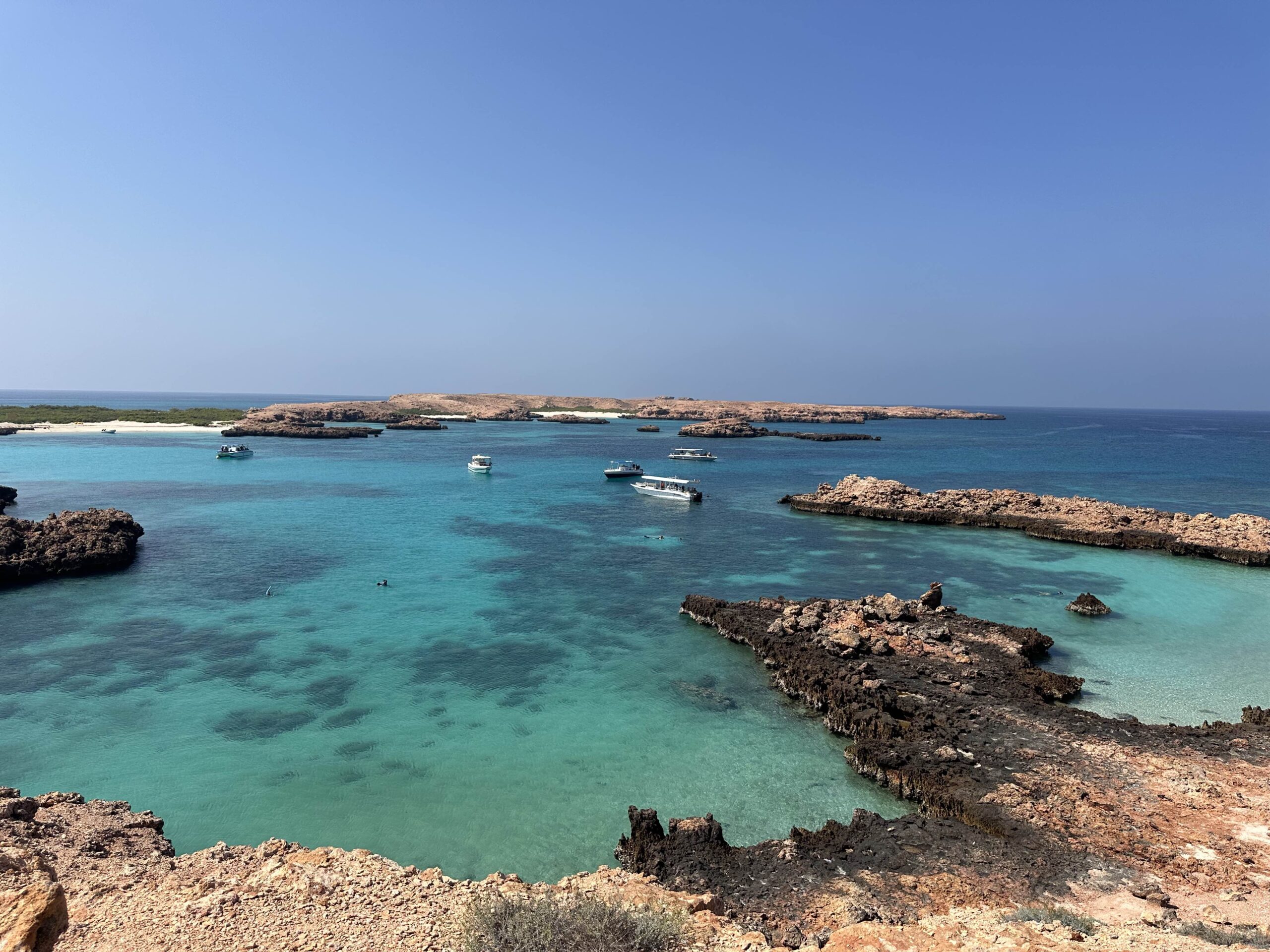 A view of the turquoise waters and boats around the Daymaniat Islands from a high point on one of the islands