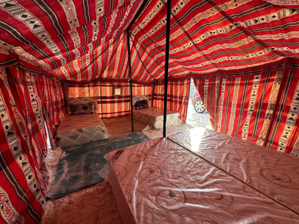 Two sets of twin beds inside a four person Bedouin-style tent