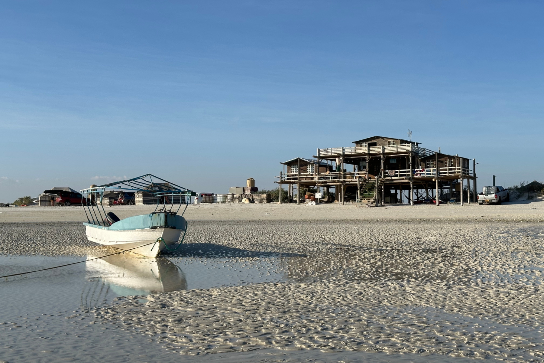 The Whales Head Camp boat at low tide with the whale station in the background