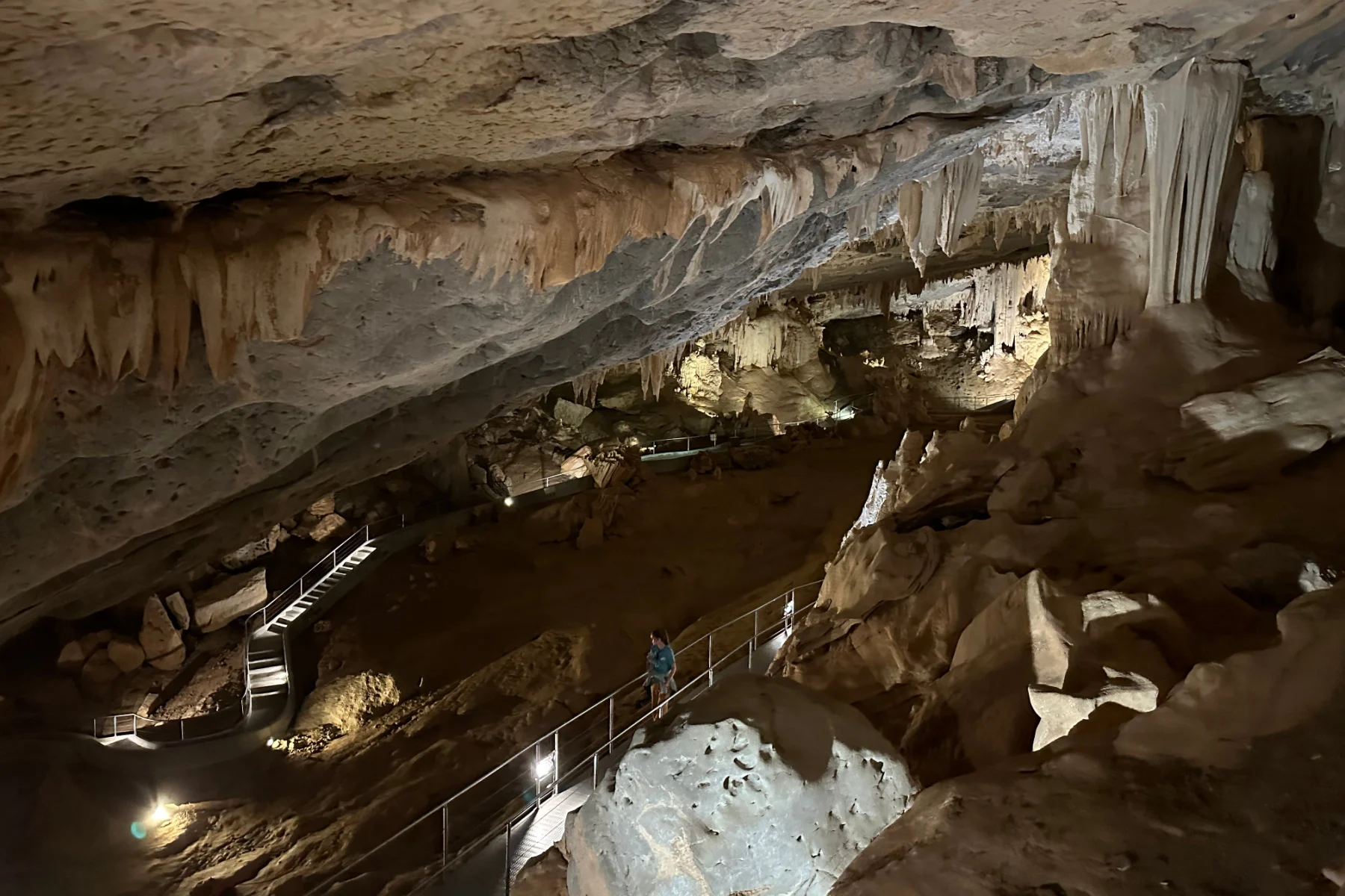 A huge cavern inside Al Hoota Cave where there are stalactites hanging from the ceiling and stalagmites coming up from the rocky floor