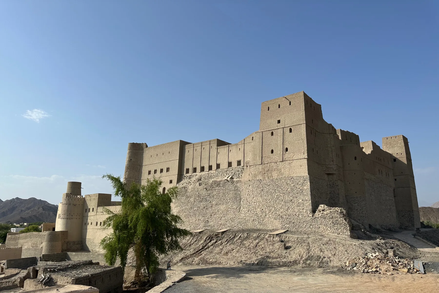 The sand coloured exterior of Bahla Fort in a mountain oasis