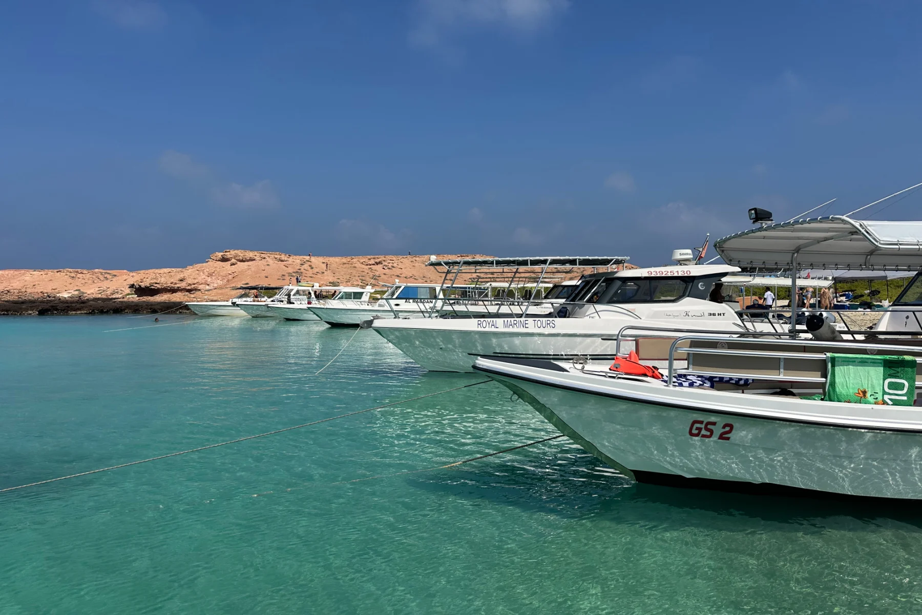 Tour boats lined up along the shore of Police Island in the Daymaniats