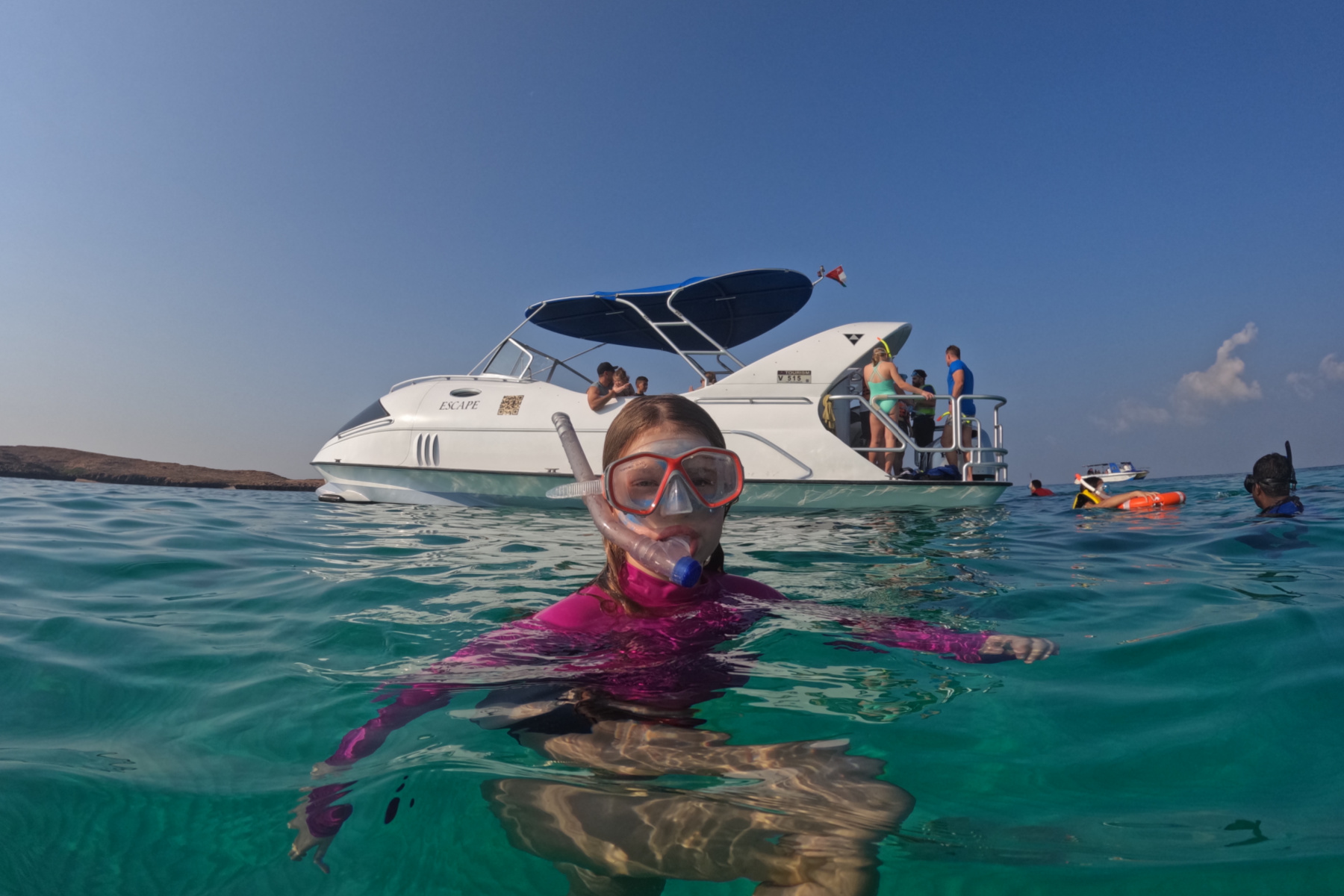 My daughter in the water in front of the Seascape tour boat. She is wearing a snorkelling mask