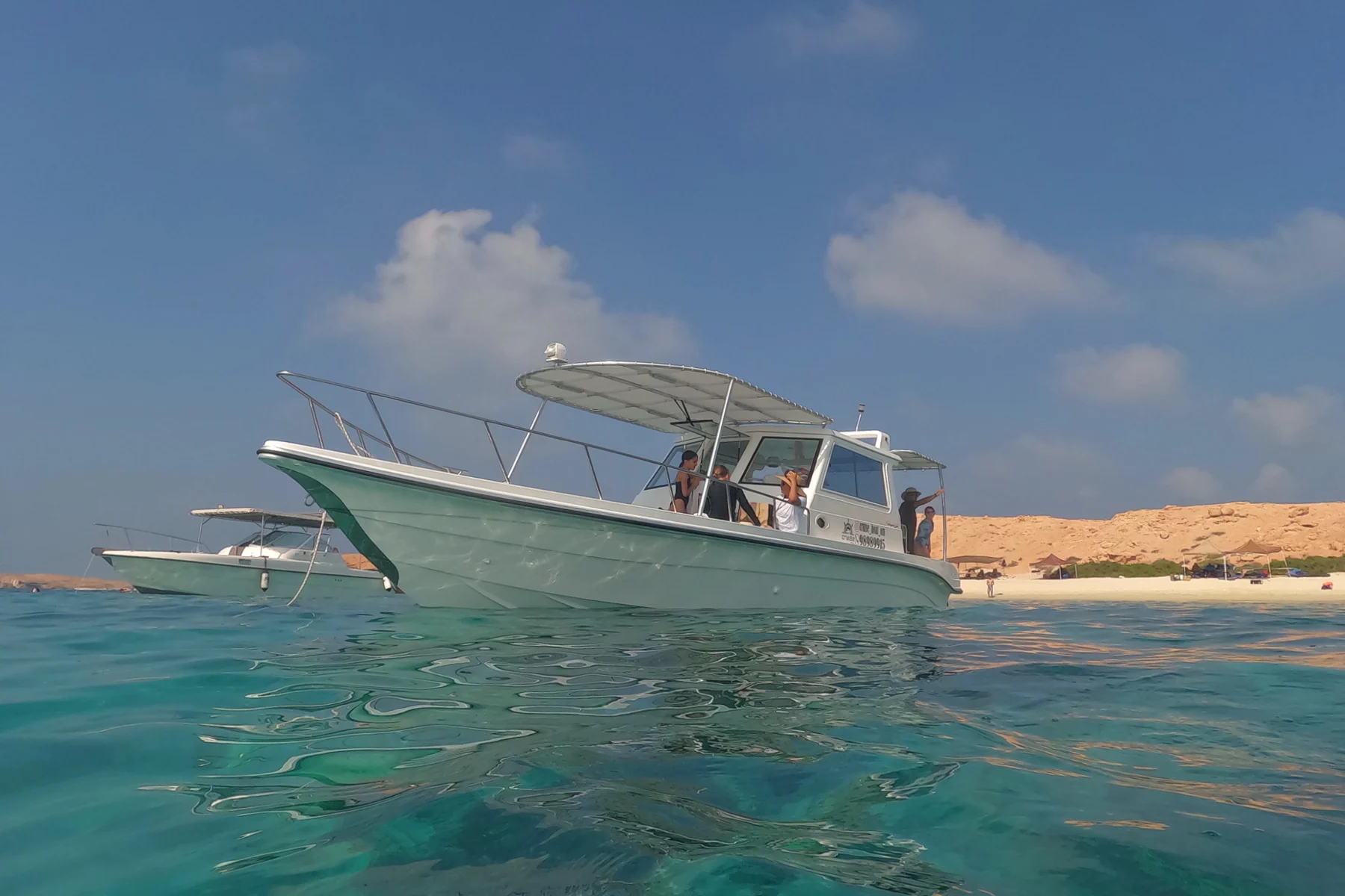 The Cruise Boat Oman boat moored near a beach