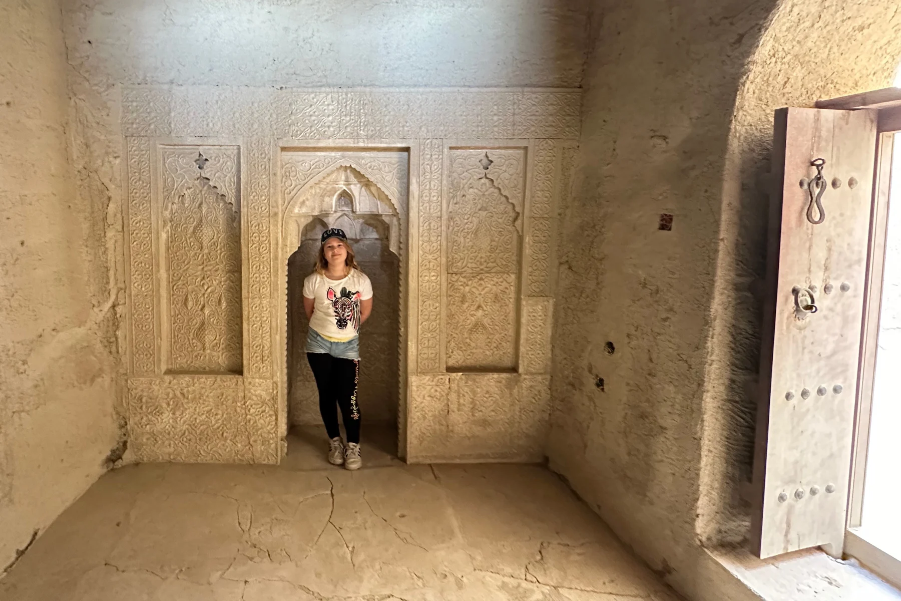 My daughter stood in the mihrab within Bahla Fort
