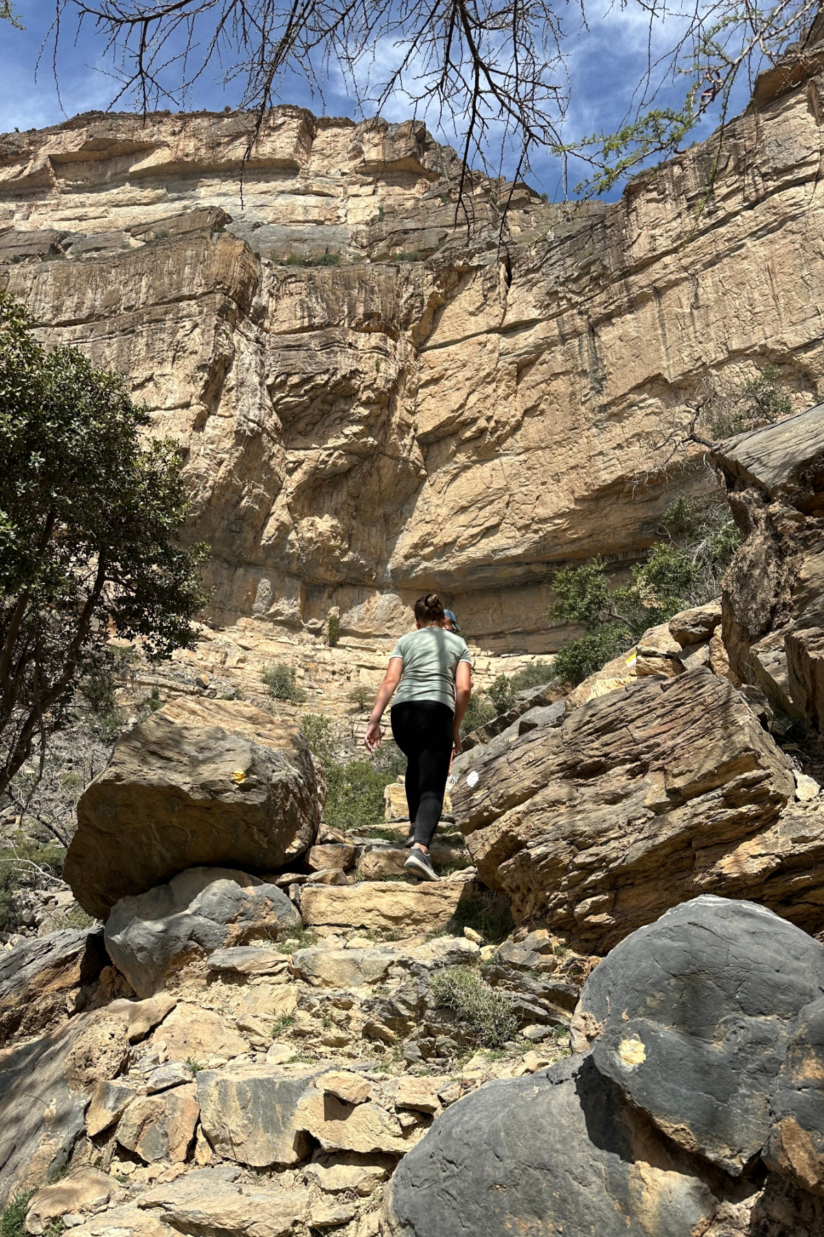 My children walking up through boulders to find the hidden pool