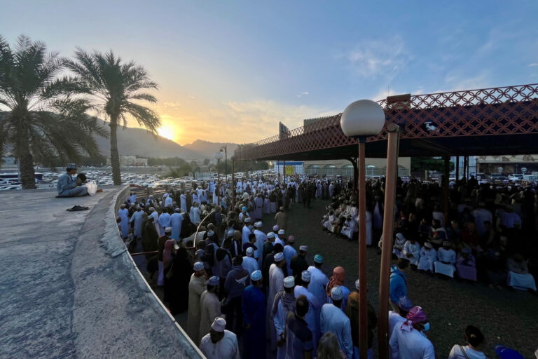 Sunrise over the Hajar Mountains seen from roof of Nizwa Goat Market. The market below is bustling with people