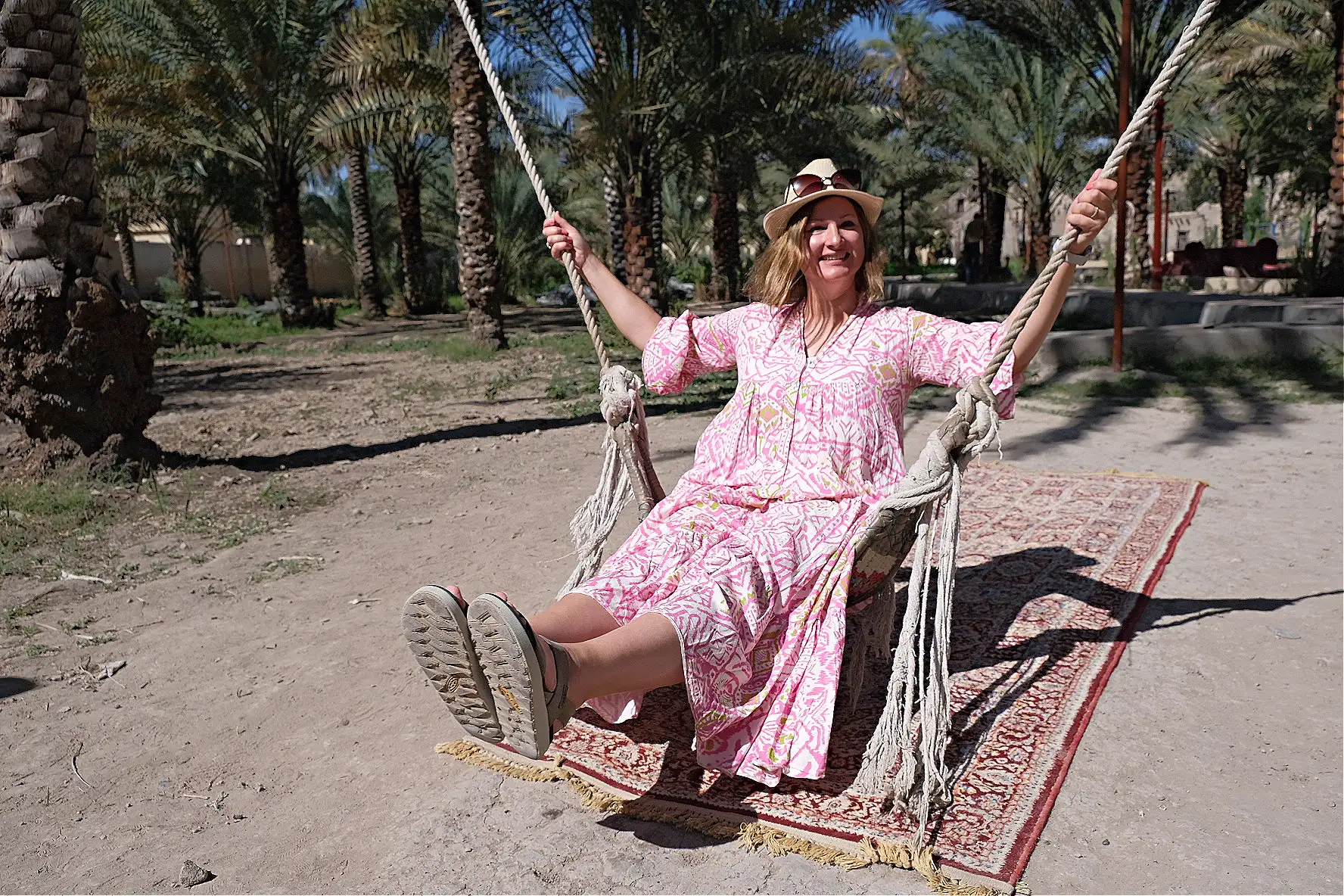 Me sat on a swing-like sling that is used to help the Nizwa Fort gardeners climb palm trees and harvest dates