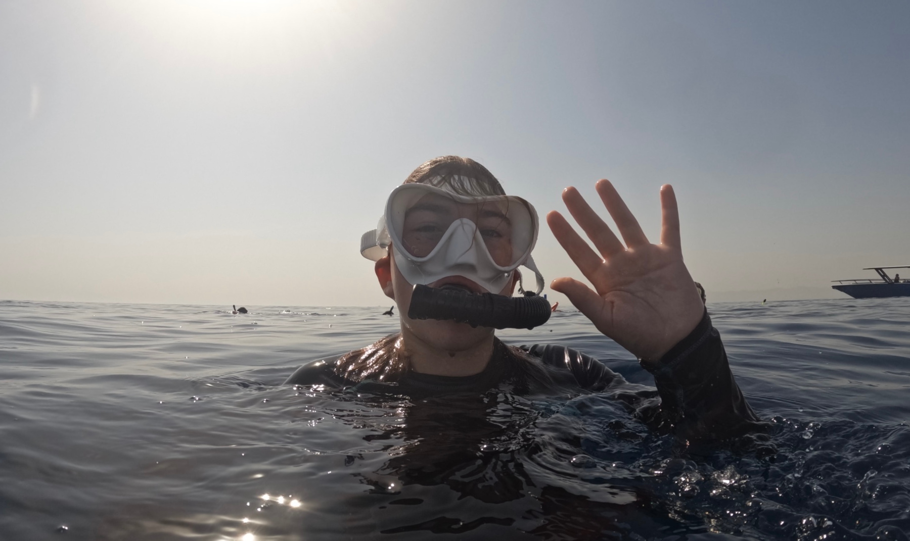 My daughter wearing a snorkel mask and waving at the camera to signal she was OK