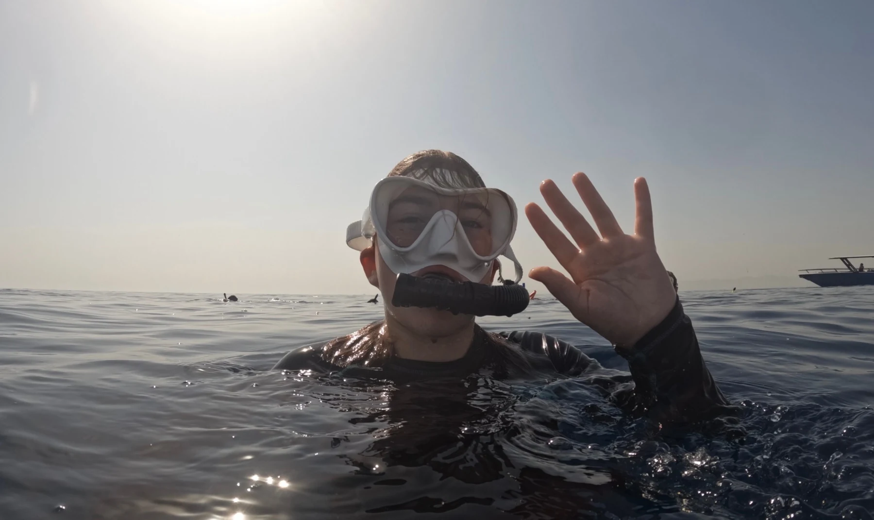 My daughter wearing a snorkel mask and waving at the camera to signal she was OK