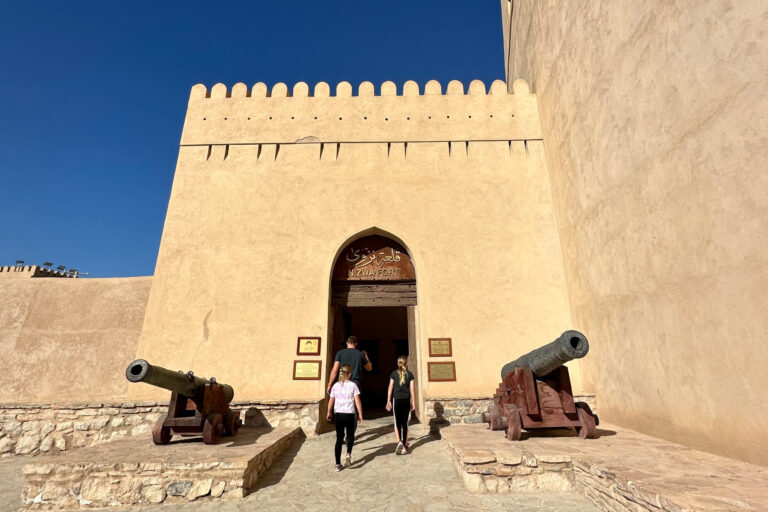 My family walking between two canons at the entrance to Nizwa Fort