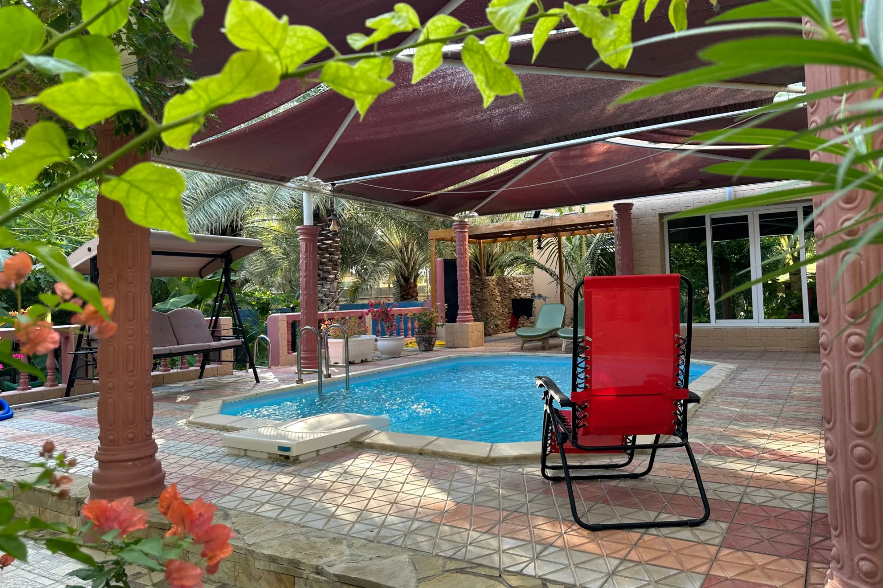 Red deck chai beside one of the outdoor pools