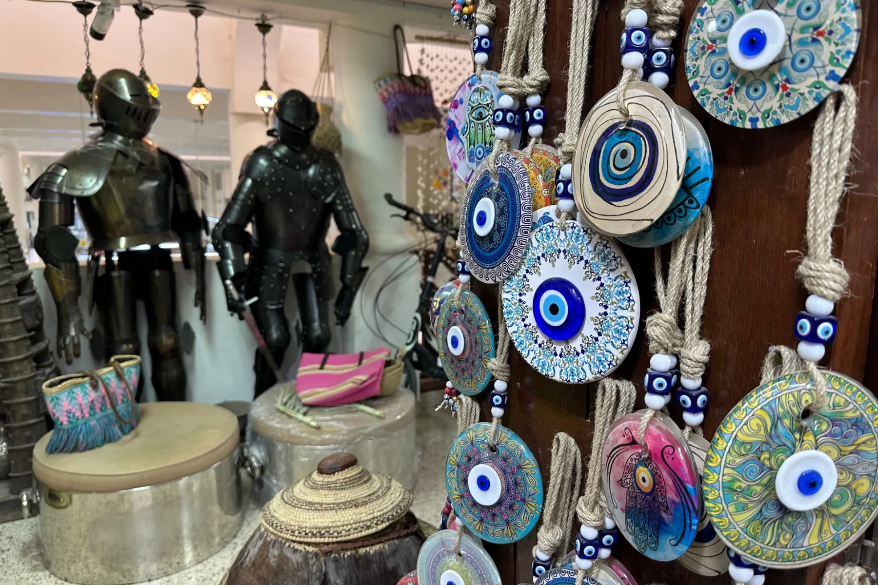 In the foreground are ropes hanging Turkish evil eye protectors. In the background are two suits of armour which are very out of place in Oman