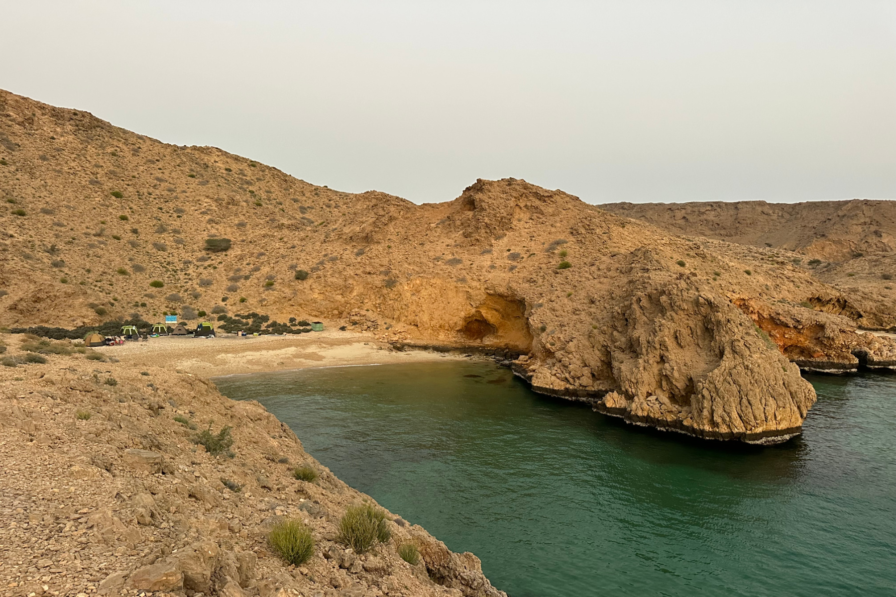 Sun rise over a cove in Bander Khayran where we have pitched tents on the beach with friends. Behind our tents there are cliffs