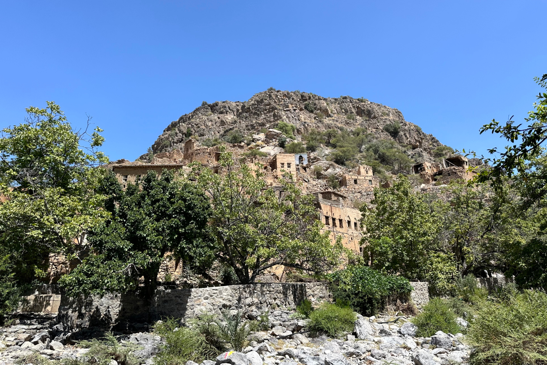 Ruined homes at Wadi Bani Habib seen from the dry river bed below