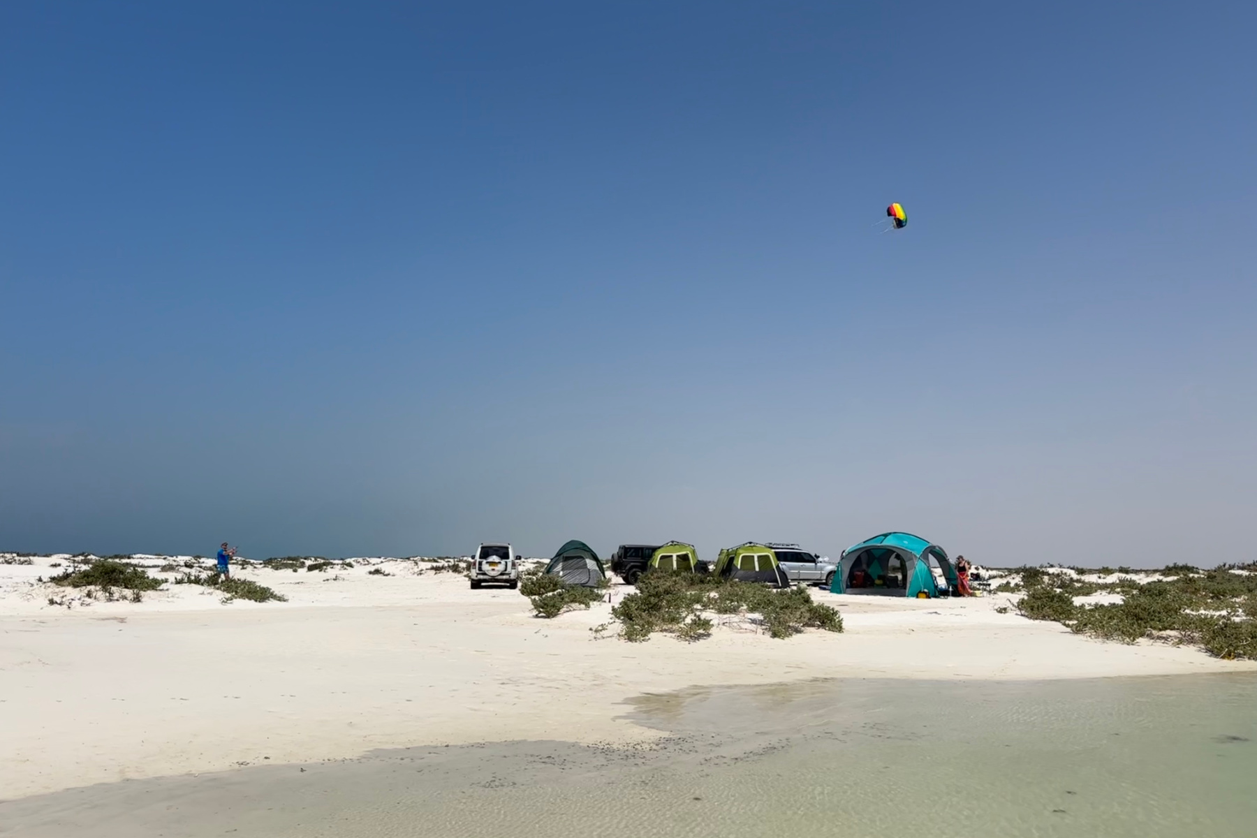 Our tents pitched beside the lagoon on Barr Al Hikman. The sand is white and the sky begins is a deep blue