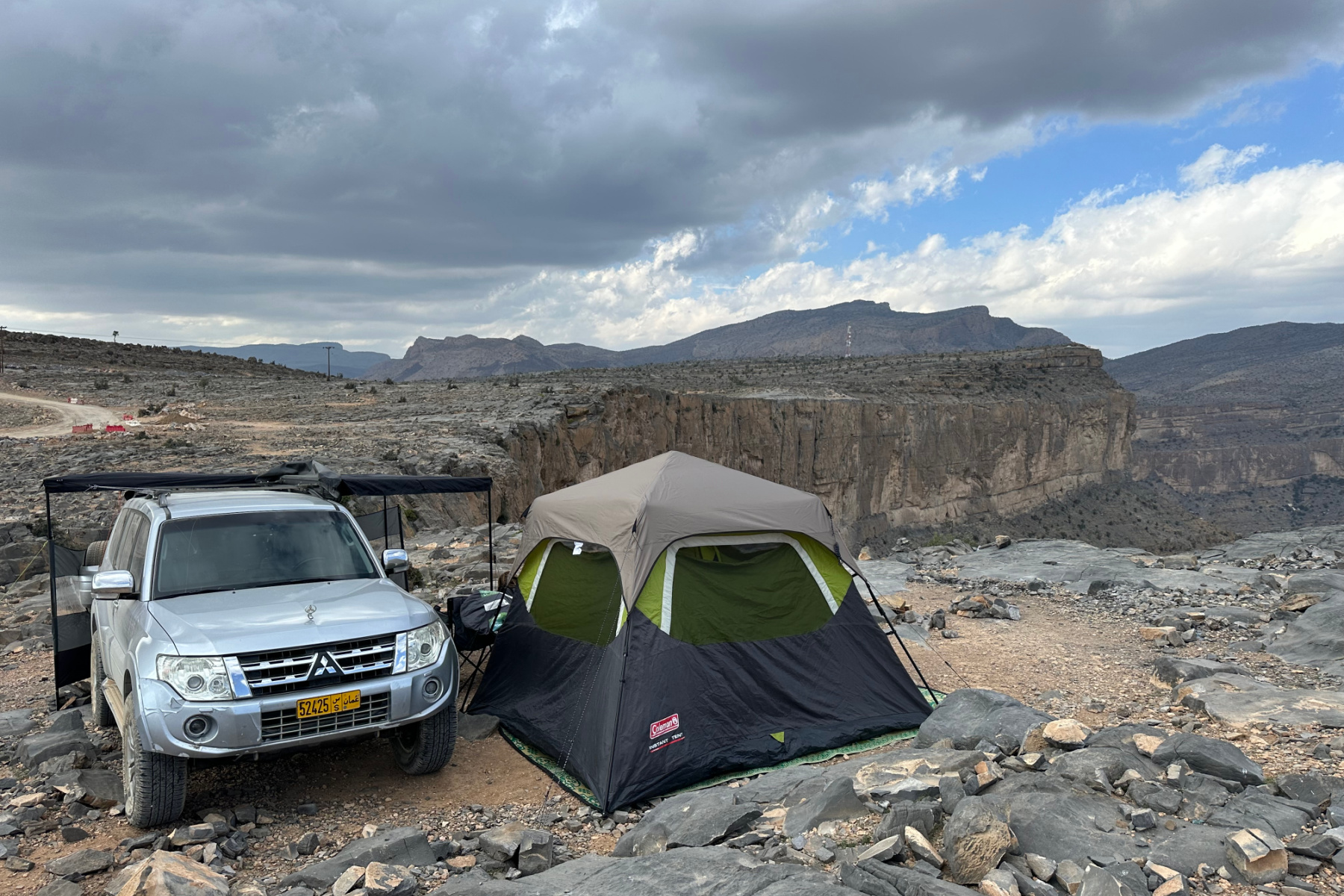 Our Pajero and tent parked on a rocky area on Jebel Shams. To the right is is possible to see the edge of the canyon