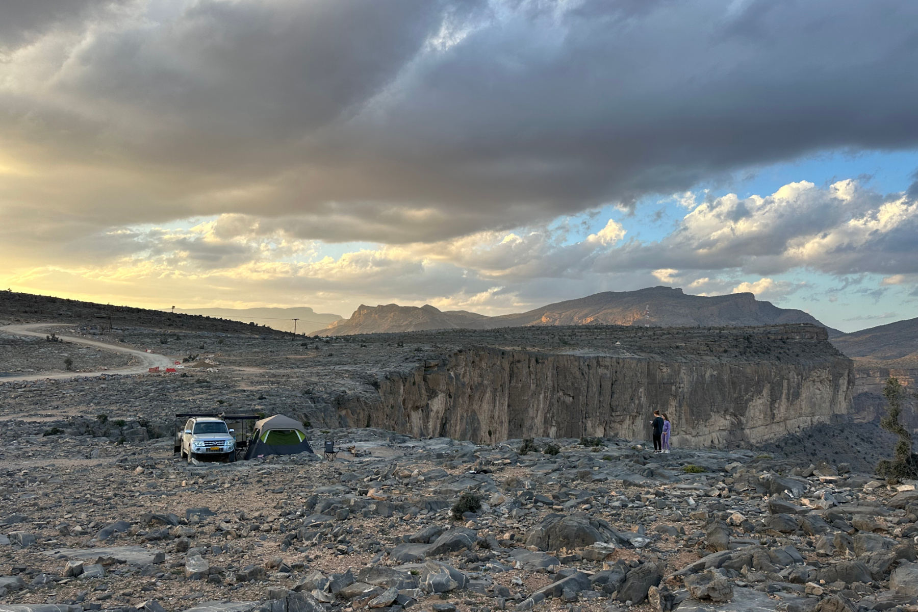 Our Pajero and tent parked on a rocky area on Jebel Shams. To the right is is possible to see the edge of the canyon