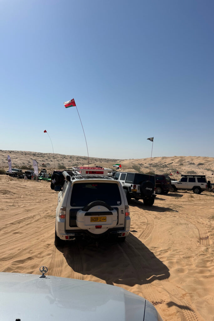 A queue of cars waiting to drive through the desert with Guide Oman