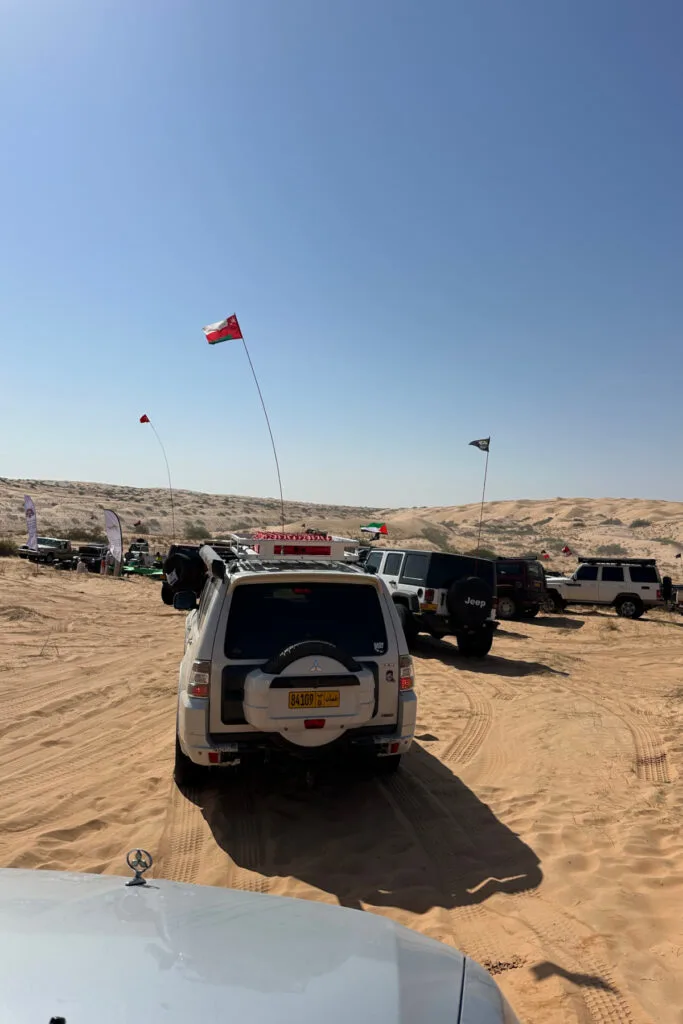 A queue of cars waiting to drive through the desert with Guide Oman