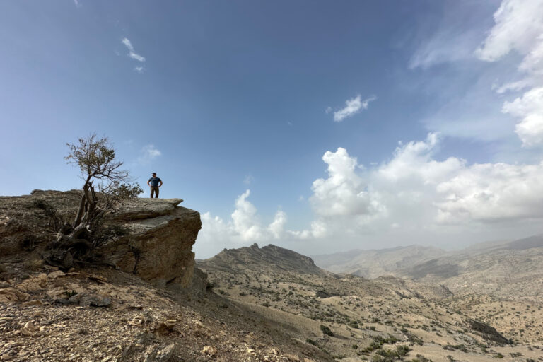 My husband standing on an outcrop on Jebel Akhdar looking at a view over the Hajar Mountains
