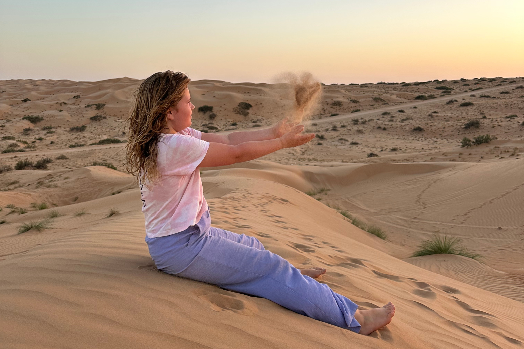 My daughter throwing a handful of sand in the air. It makes the shape of a fairy