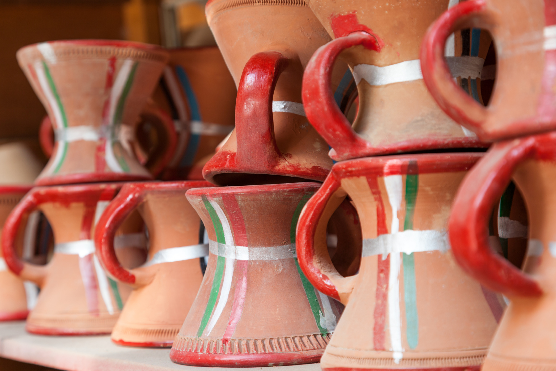 Traditional pottery incense burners painted in the colours of the Omani flag