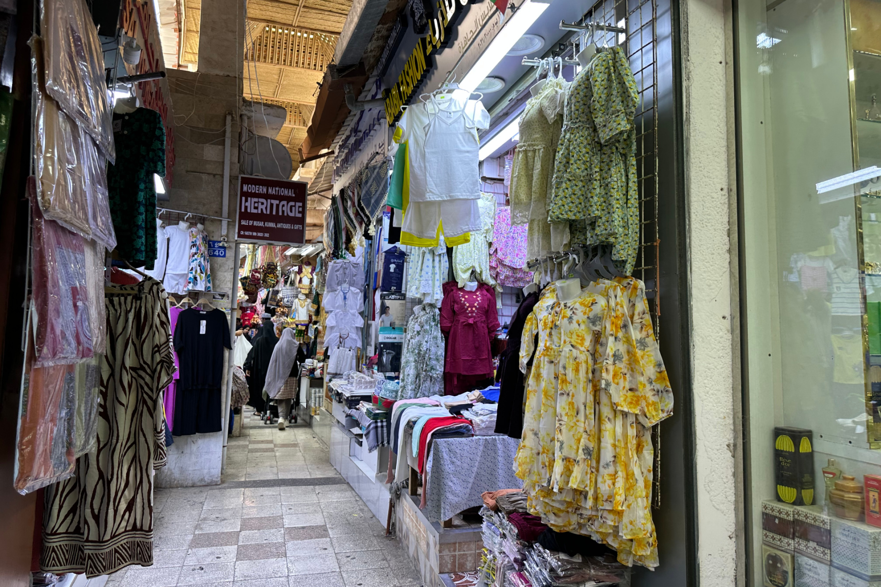 Clothes hanging outside shops in a narrow alley of Muttrah souq