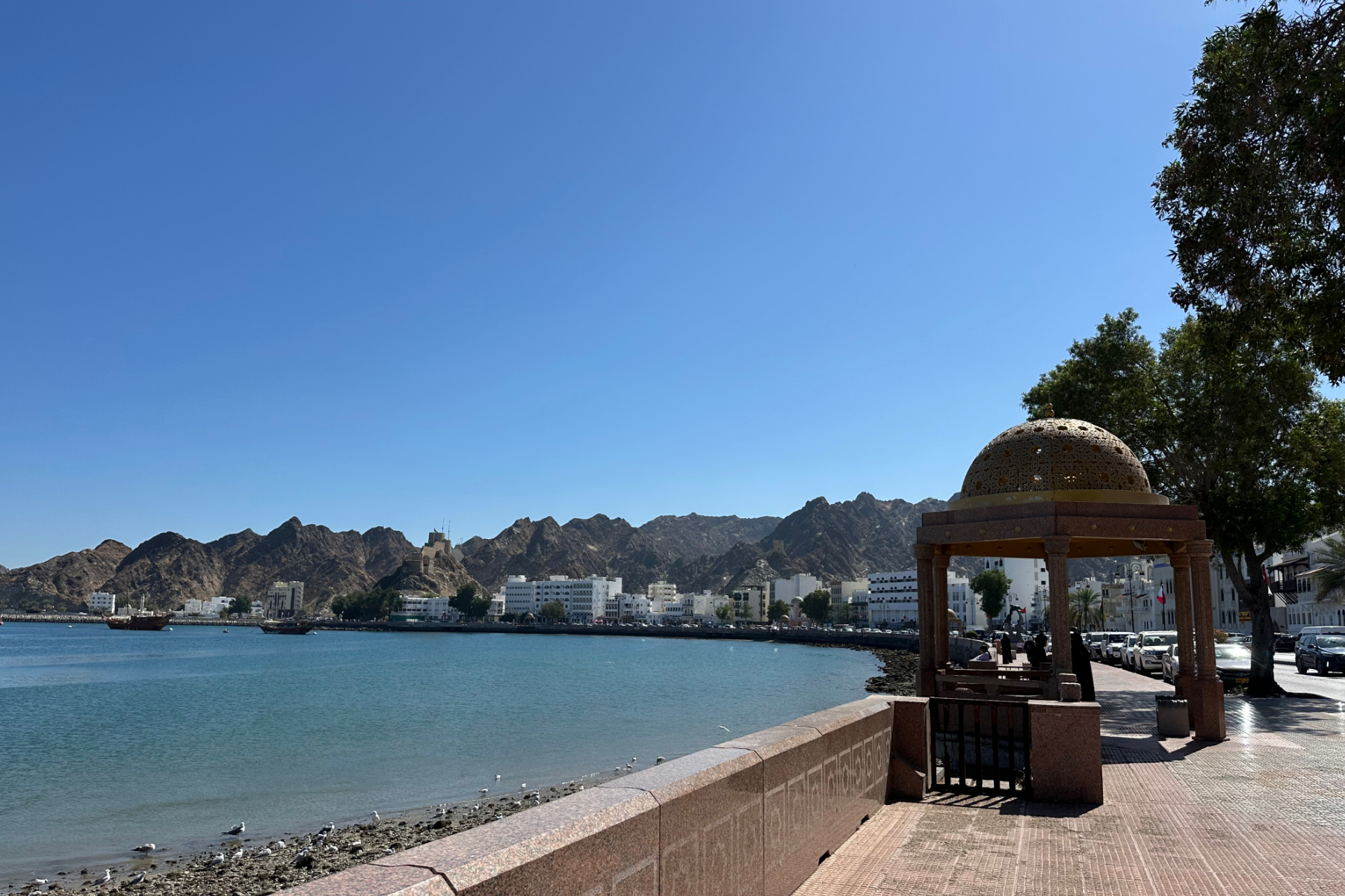 A domed seating area and view of the harbour fom Muttrah corniche