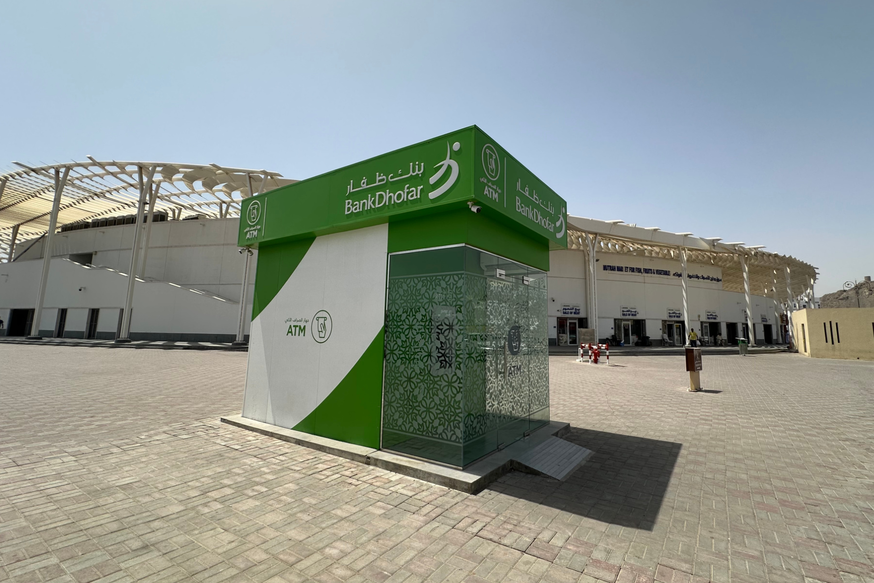 A small green building that houses a cash machine for Sohar Bank outside the fish market in Muttrah