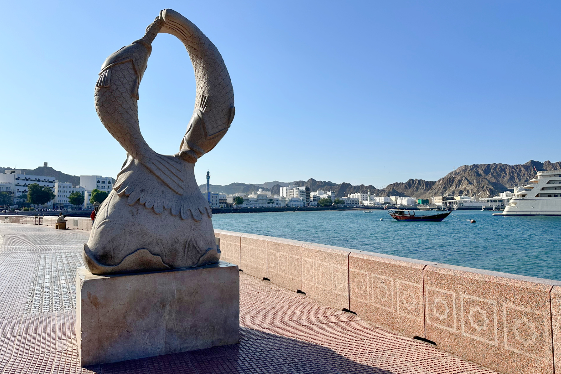 A statue of splashing fish made of granite on the corniche at Muttrah