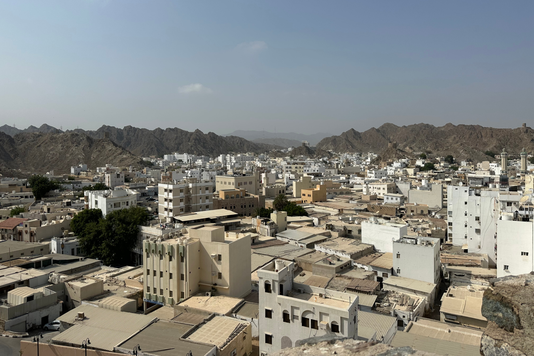 A view over the flat roof tops of Muttrah with the mountains that contain the old city in the background