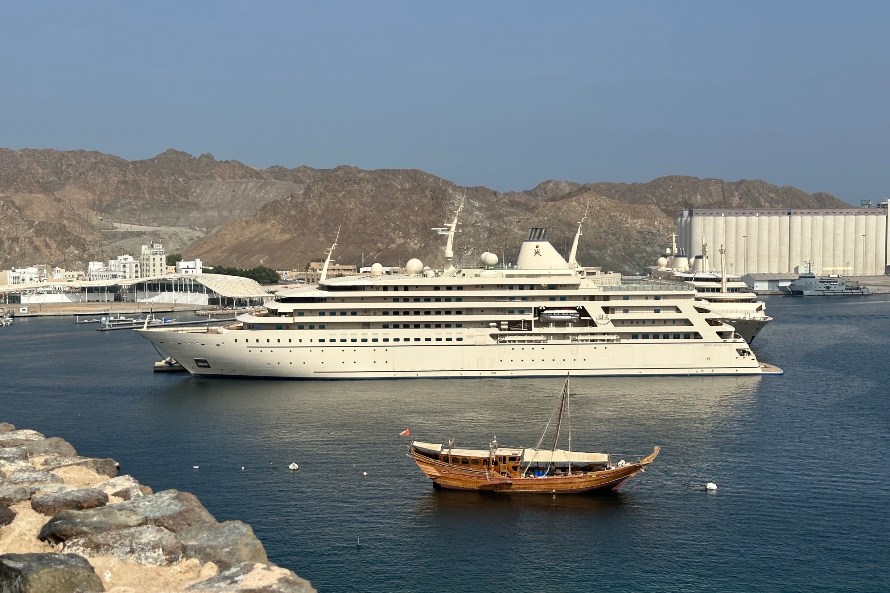 Sultam Haitham bin Tariq Al Said's royal yacht in Muttrah Harbour with a dhow moored in front