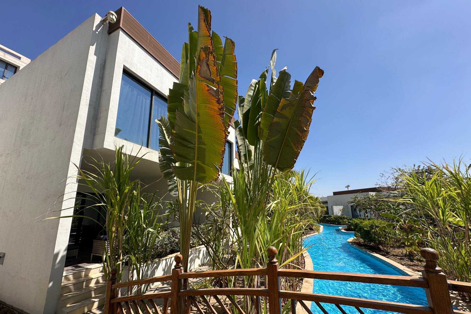 Our pool-side family villa at Millennium Resort wth palm trees planted between the covered terace and lazy river