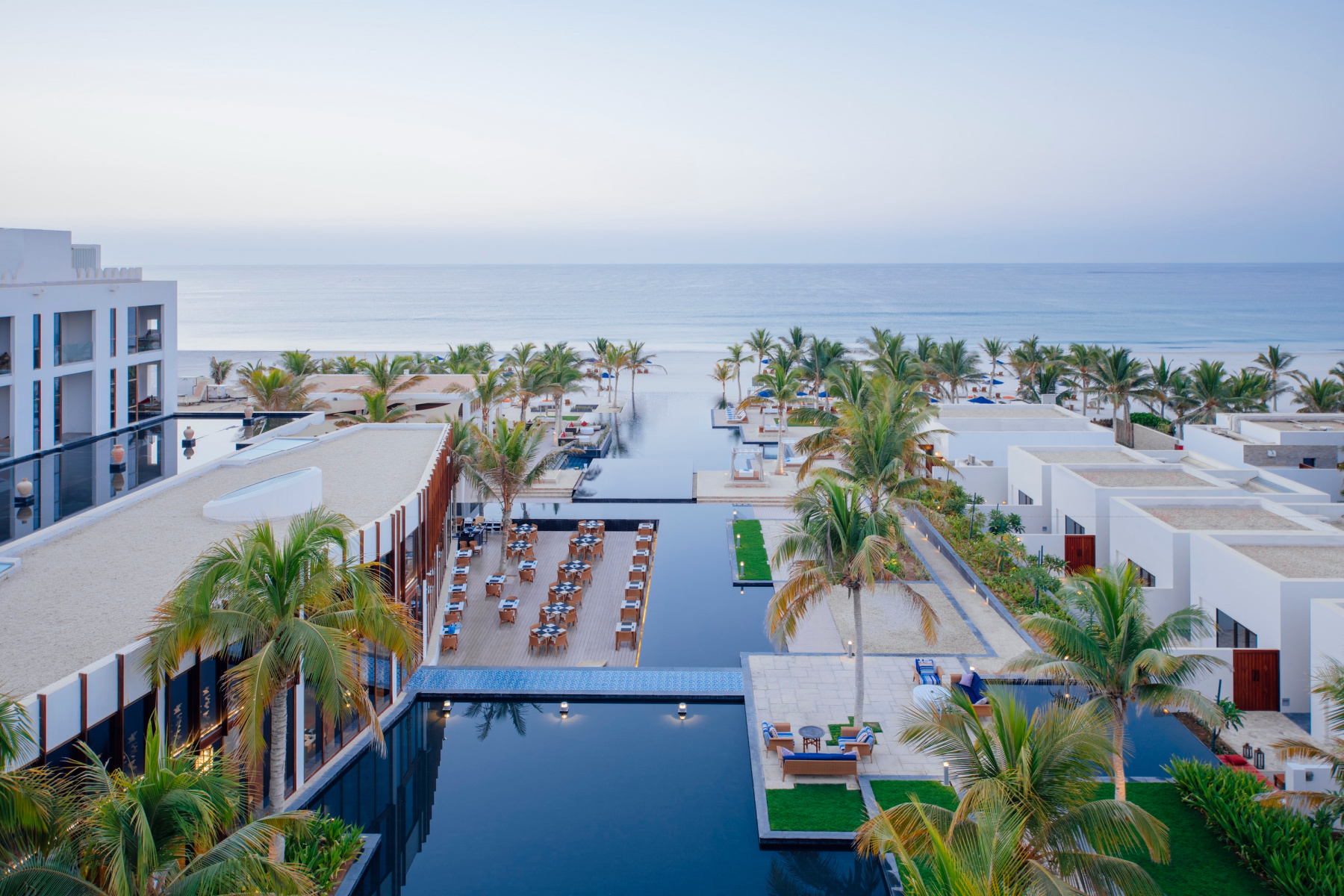 A view over the pools of Al Baleed Resort by Anantara towards the sea