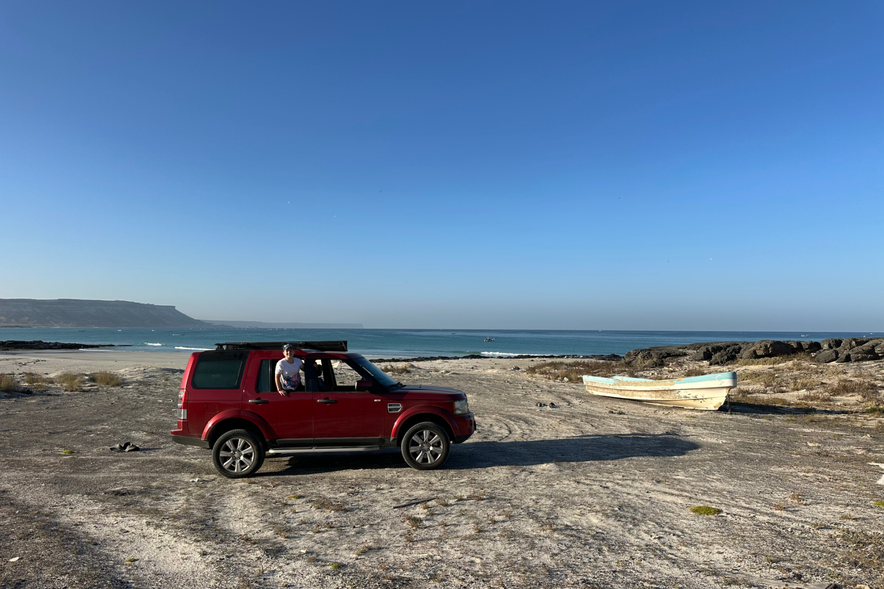 Our car parked on the beach at Ras Madarakah. There is a fishing boat in the background