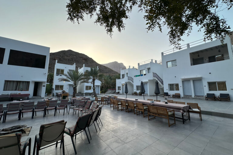 The outdoor seating and dining space at the hotel with the accommodation in the background