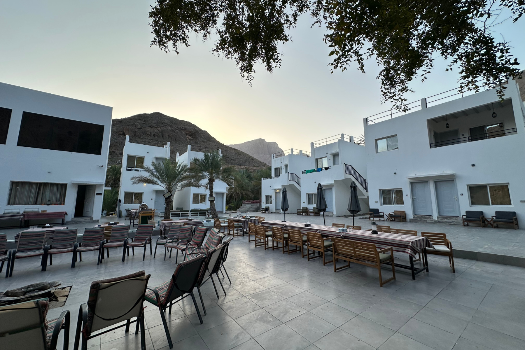 The outdoor seating and dining space at the hotel with the accommodation in the background
